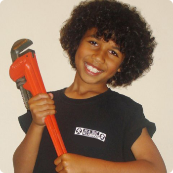 kid wearing in and out plumbing shirt and holding a wrench